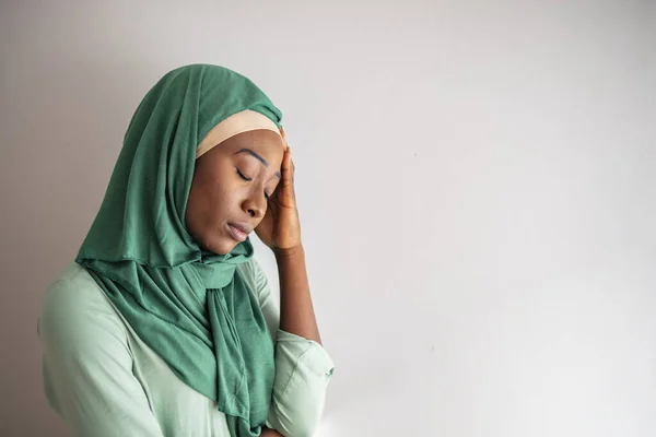 Middle aged muslim woman wearing hijab stressed with hand on head. Muslim office lady resting by the window and having headache because of the annoyed customer. Negative work concept