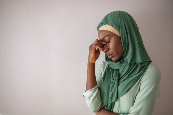 Arab saudi emirates woman with head ache. Portrait of unhappy young woman with bad headache. Portrait of beautiful young muslim woman with bare shoulders touching her temples feeling stress