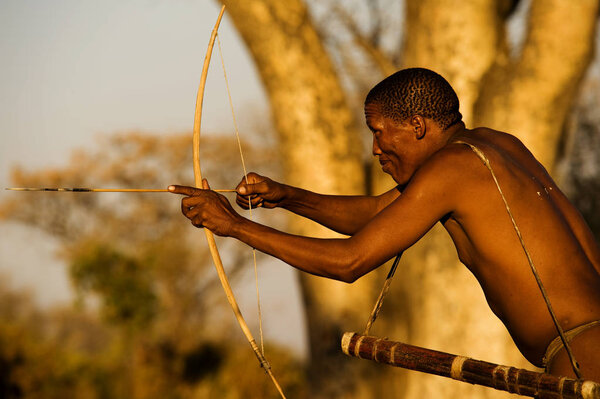 Bushman simulating a hunt with bow