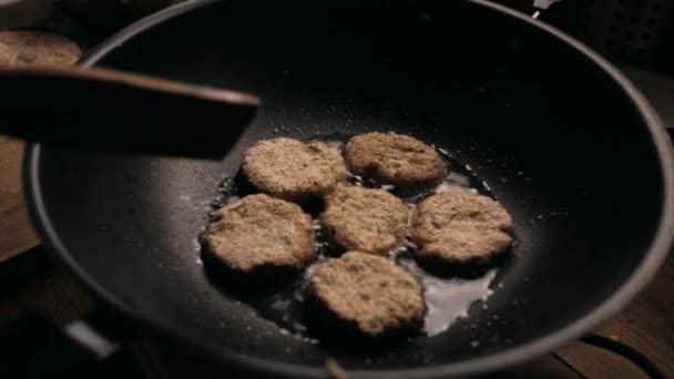 Шеф-повар готовит вегетарианские бургеры на сковороде — стоковое видео