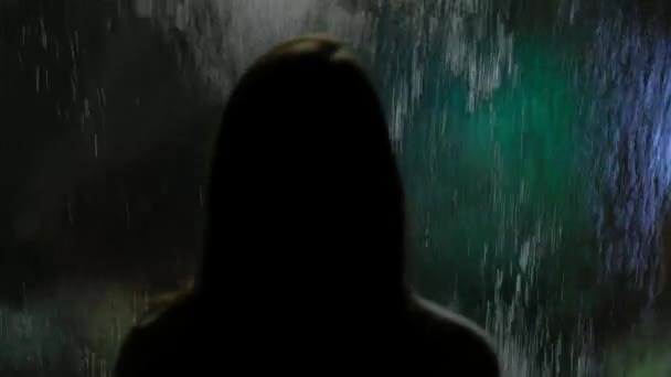 Das Mädchen mit langen Haaren und weißen Nägeln im Ozeanarium, passt mit dem fließenden Wasser an die Glaswand — Stockvideo