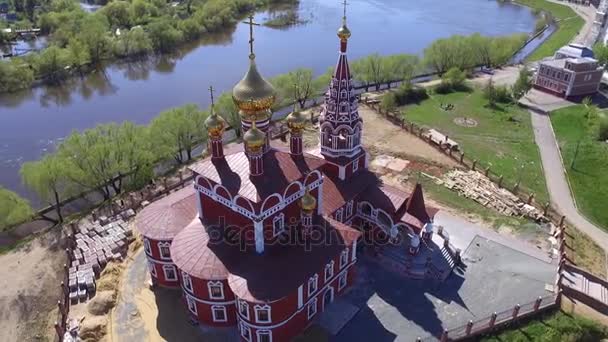 Luchtfoto Drone Shot: Mensen komen naar de kerk op een zomerdag, een grote kerk op de grote rivier — Stockvideo