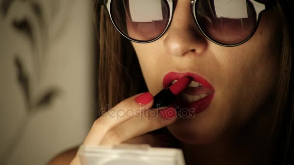 La hembra en negro gafas pintar labios rojo lápiz labial — Vídeo de stock