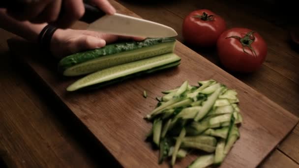 Primer plano: la mujer corta el pepino en el cuchillo de cerámica de mesa de madera — Vídeos de Stock