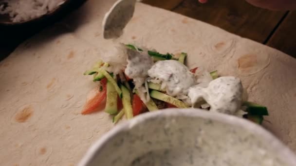 Κοντινό πλάνο - θηλυκό προσθήκη Souse σε πίτα με κοτολέτες και κόβει τις ντομάτες και τα αγγούρια — Αρχείο Βίντεο
