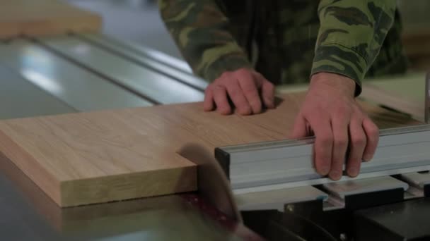 Trabajador en madera de aserrado de camuflaje en la máquina, madera de aserrado en un telar circular, el trabajo en el taller — Vídeo de stock