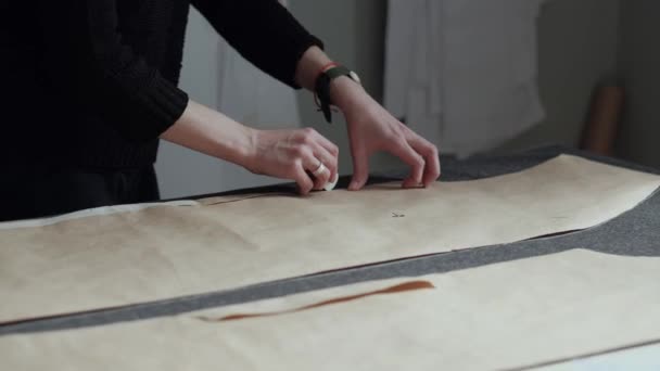 Diseñador de moda crea ropa en el taller, dibuja con tiza en la tela — Vídeo de stock