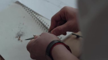 Yakın çekim: Adam netlik bıçak siyah kalem, defterini arka plan üzerinde