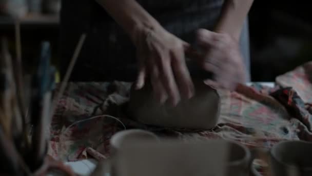 Young Potter trabaja en taller, arcilla amasada en la mesa, manos de primer plano de Potter — Vídeo de stock