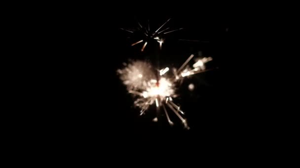 Nahaufnahme - Wunderkerze brennt im Dunkeln, auf schwarzem Hintergrund, heller Funken — Stockvideo