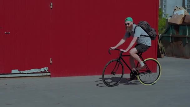 De bebaarde man is de zwarte Vintage fiets rijden in zonnige zomerdag — Stockvideo