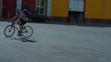 Sakallı adam yaz gün, siyah şort, yeşil şapka, gözlük, sırt çantası siyah Vintage Bisiklete biniyor