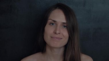 Kameraya gülümseyen, siyah arka plan üzerine mutlu portre seyir ve etkileyici mavi gözlü oldukça şaşırtıcı neşeli kız esmer