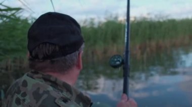 Arkadan Görünüm: Balıkçı Budak balık, kamuflaj balıkların bir tekne sazlık gölde bir erkekte