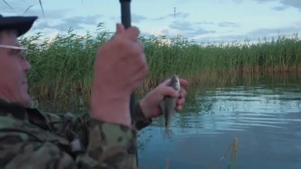 Le pêcheur a attrapé un poisson et le montre à la caméra — Video