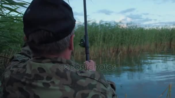 Rybář chytil rybu a ukazuje na kameru — Stock video