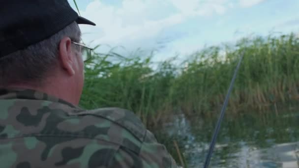 Рыбалка пожилого человека в реке летом — стоковое видео