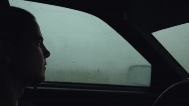 La Silhouette du Conducteur en Voiture, le Conducteur attend le mauvais temps dans la Voiture, Alerte de tempête, Mauvais temps sur la Route, Pluie battante — Video