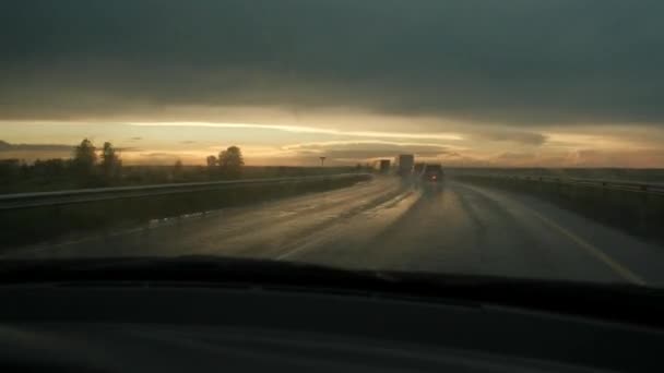 雨の後の街の外での雨の道路交通のタイムラプス魅力的な景観の背景にある日没で — ストック動画