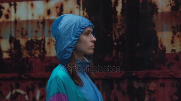 Slowmotion, Dziewczyna samotny spacer po deszczu, Stepping w kałuży, w deszczu, w jasny kolorowy płaszcz, buty gumowe niebieski — Wideo stockowe
