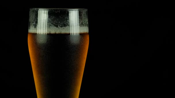 Pouring Beer Closeup. Pint of Cold Craft Beer Isolated on Black Background. Rotation 360 Degrees. 4k Uhd — Stock Video