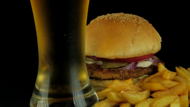 Comida rápida americana típica - Hamburguesa con papas fritas, sobre fondo negro — Vídeo de stock