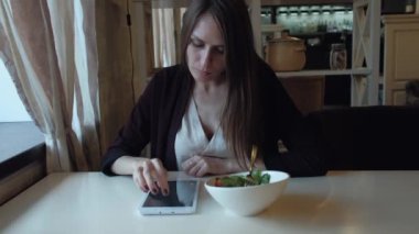 Kadın şehirde bir kafede öğle yemeği yiyor.