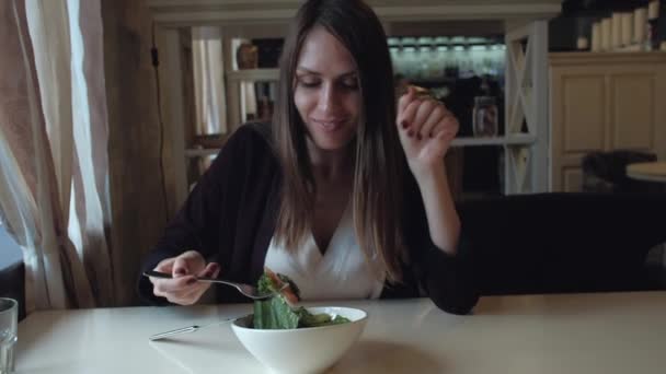 Žena jíst salát, posezení v kavárně ve městě — Stock video