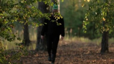 Adam parkta yürüyor. Doğrudan gözlerinin içine bakar.