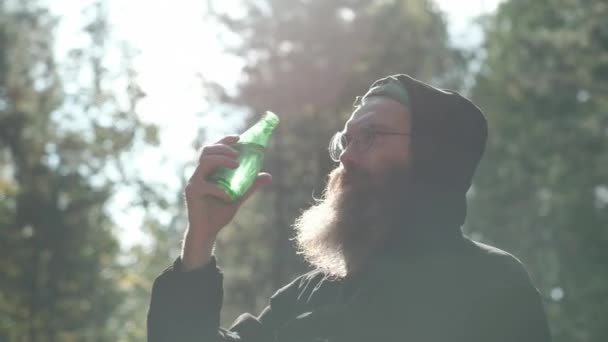 Brodaty mężczyzna pije wodę mineralną. — Wideo stockowe