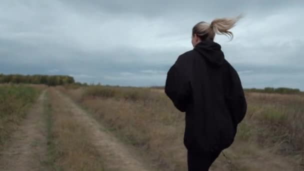 Rubia hembra tomando el sol en anorak negro — Vídeo de stock