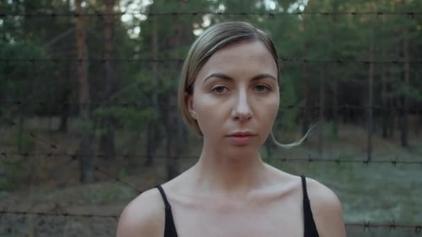 Portrait of female migrants against the background of barbed wire — Stock Video