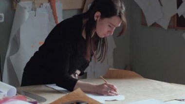 Terzi düzeni için giysiler çizer.