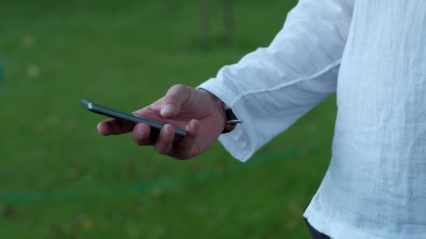 Mains masculines utilisant le téléphone intelligent 