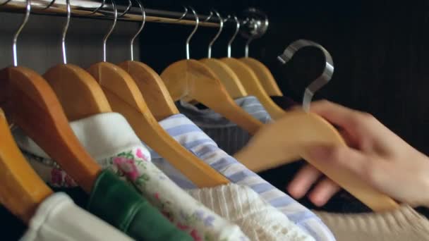 Frau wählt Kleidung im Kleiderschrank — Stockvideo
