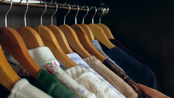 Женщина выбирает одежду в гардеробе — стоковое видео