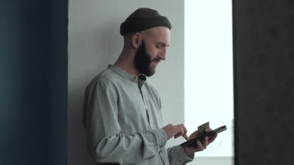 Mann mit Bart kauft online mit Kreditkarte und Tablet zu Hause — Stockvideo