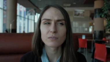 Sağ ve sol tek başına kafede otururken şüpheli duygu isteyen genç ciddi kadın