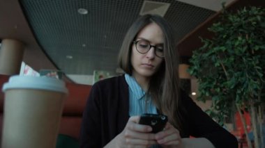 Slowmotion - smartphone kullanarak ve kafede kahve içme sevimli erkek.