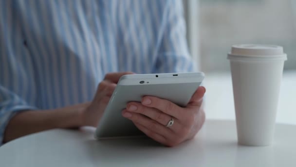 Frau sitzt in Cafeteria und nutzt digitales Tablet — Stockvideo