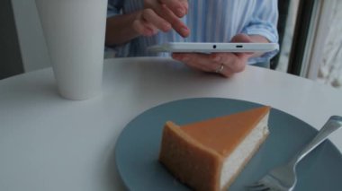 Kadın kafeteryada oturan ve dijital tablet kullanma