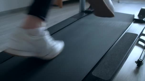Evde koşu bandı üzerinde çalışan erkek ayağı — Stok video