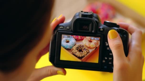 Frauenhände fotografieren mit Fotokamera köstliche Donuts in Schachtel. — Stockvideo
