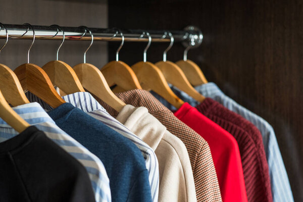 Вешалки с различной одеждой в шкафу
.