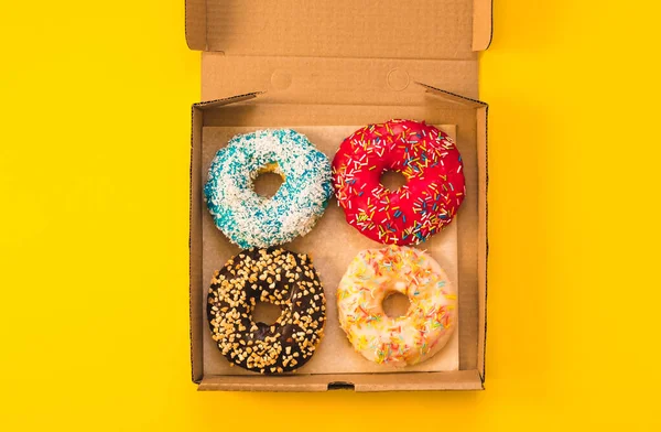 The Delicious 4 donuts lying on carton box.