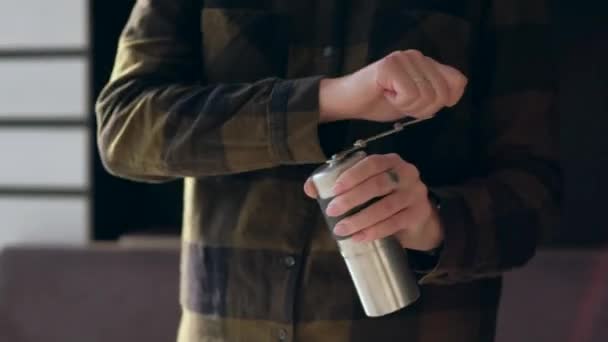 Handen vasthouden koffiemolen en wikkelen zijn handvat tijdens het malen van koffiebonen. — Stockvideo