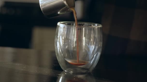バリスタは、透明なマグカップにいれたてのコーヒーを注ぐ. — ストック動画