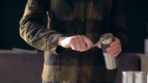 Händerna håller kaffekvarnen och lindar sitt handtag vid malning av kaffebönor. — Stockvideo