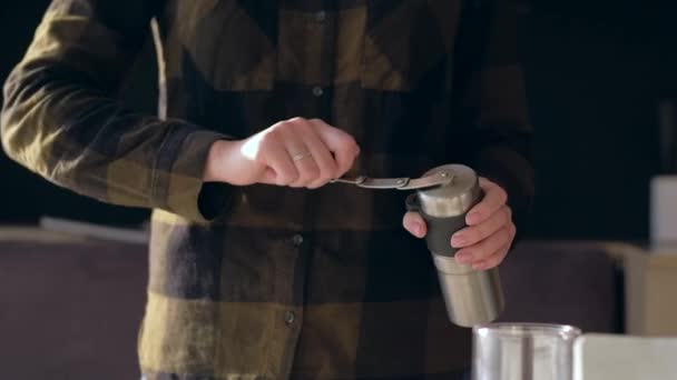 Händerna håller kaffekvarnen och lindar sitt handtag vid malning av kaffebönor. — Stockvideo