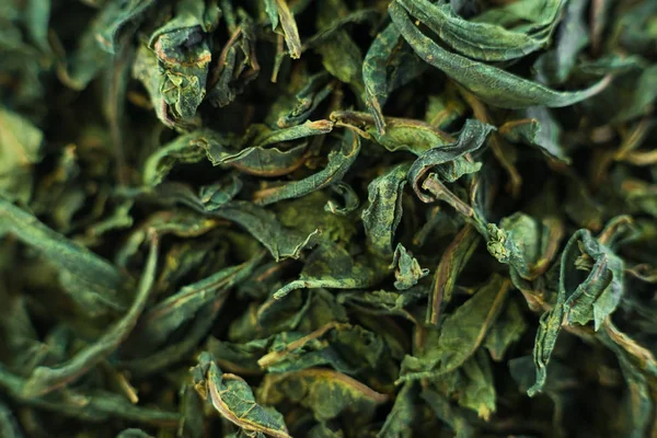 Close-up dried green tea leaves rotating 360 top view.